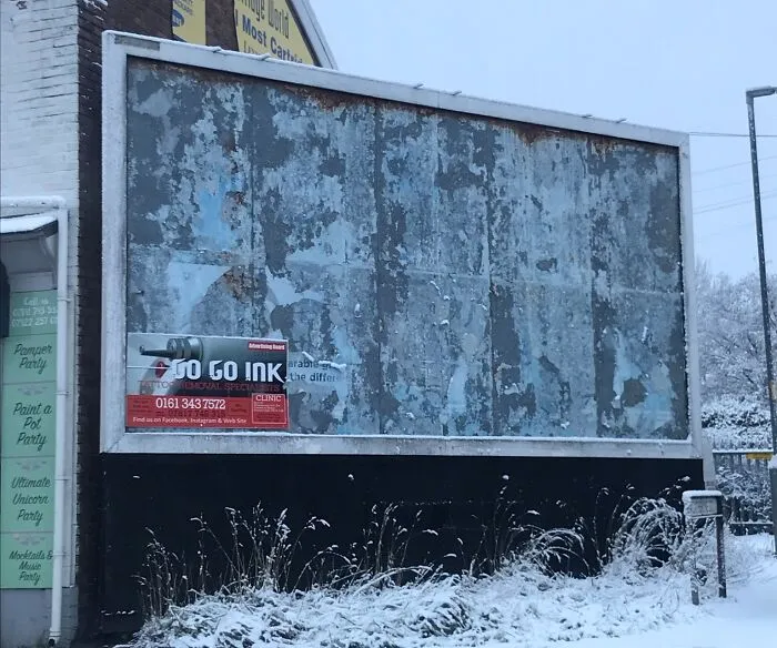 Cartel publicitario deteriorado en ambiente nevado, ejemplo de divertidos fallos publicitarios que cuesta creer.