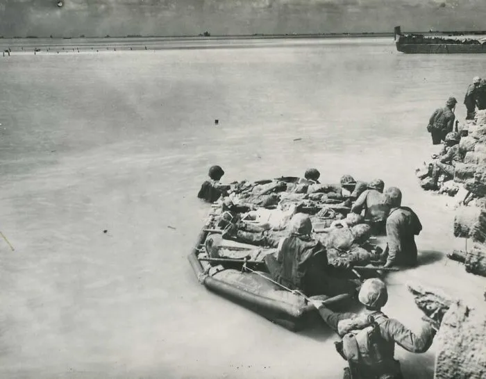 Battle Of Tarawa. Wounded Being Evacuated At End Of Pier Aboard Rubber Boats