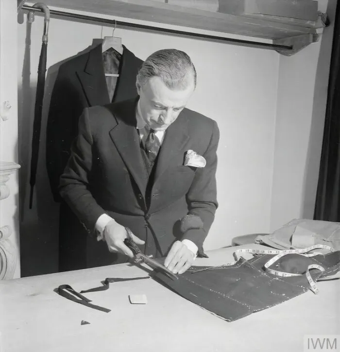 In The Tailoring Room At The Fashion House Of Designer Norman Hartnell In London, Master Tailor Monsieur Jean Cuts A Model Suit