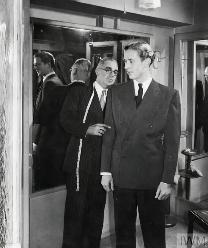 The Master Tailor Of A London Tailoring Firm (Probably Anderson's On Savile Row) Makes A Final Inspection Of The Recently-Completed Suit Of A Customer