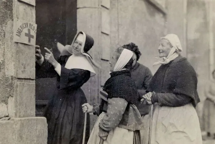 Nun Bringing Women Whose Husbands And Sons Are At War To The American Red Cross Dispensary For Treatment,  Circa 1914-1918