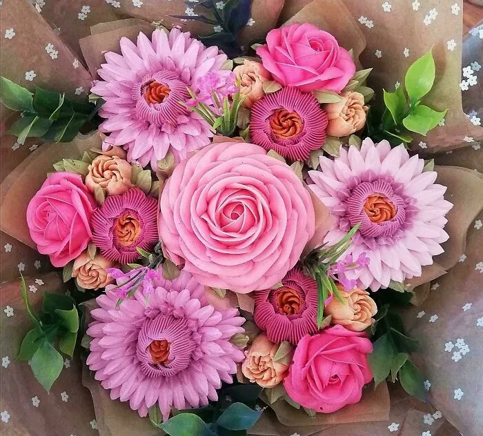 Intricately designed baked goods resembling a bouquet of pink and purple flowers, showcasing kitchen artistry.