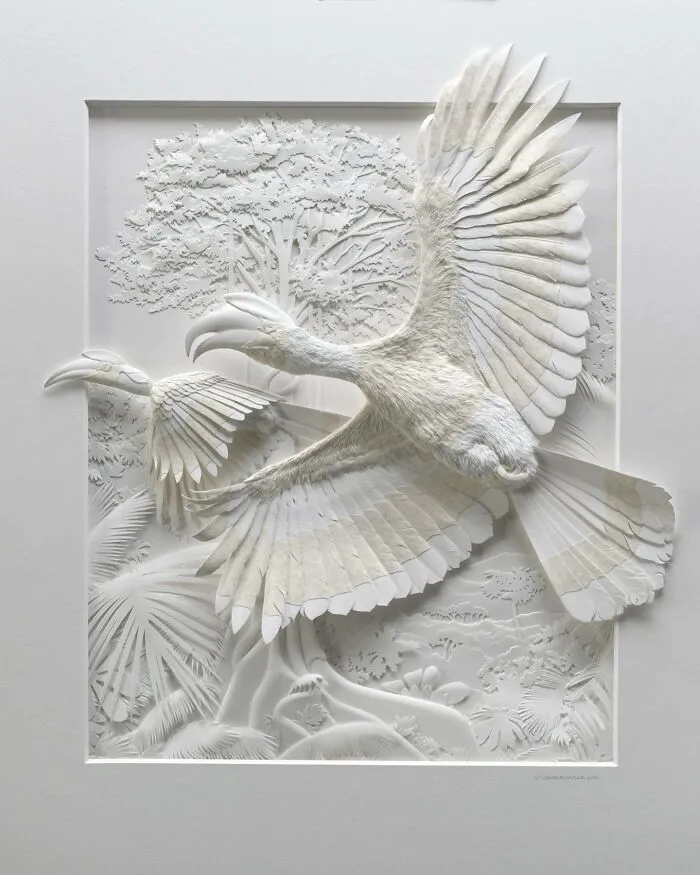 Realistic wildlife sculpture of a detailed bird in flight made from intricately crafted simple white paper layers.