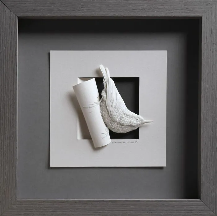 Realistic wildlife paper sculpture of a bird emerging from a curled paper in a framed display, showcasing detailed texture and form.