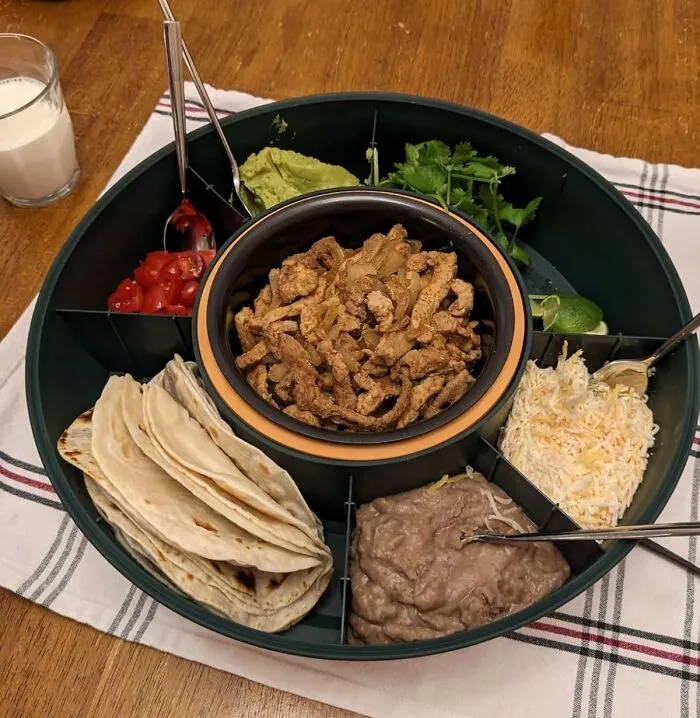 Round serving tray with taco ingredients including seasoned meat, tortillas, guacamole, cheese, and refried beans for impulse buys
