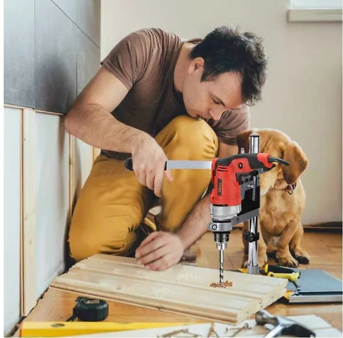 Hombre usando un taladro mal editado en Photoshop y un perro observando, ejemplo claro de Photoshop fails horribles.