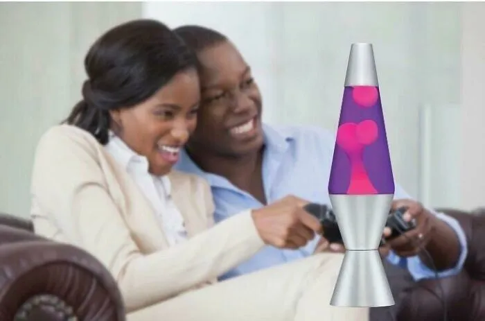 Pareja sonriente jugando videojuegos en casa con una lámpara de lava, ejemplo de errores de Photoshop impactantes.