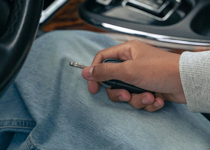 Person holding car key while sitting inside a vehicle, illustrating wild and embarrassing drinking stories and poor decisions.