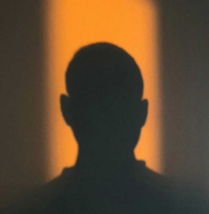 Silhouette of a person against an orange light, illustrating unusual moments caught on home security camera footage.