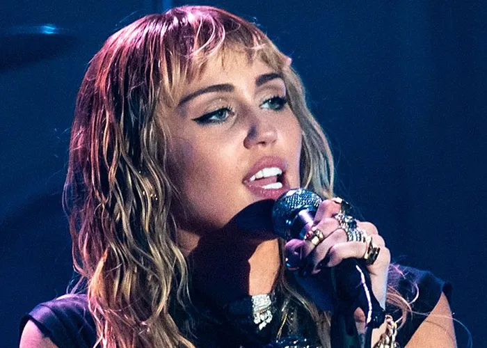 Female celebrity singer performing on stage, holding a microphone, showcasing a wild and memorable experience with a total gentleman.