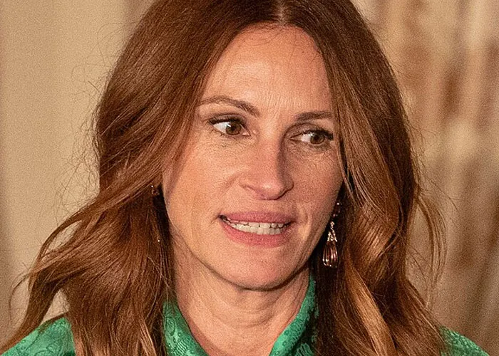 Close-up of a woman with wavy brown hair sharing a story about running into celebrities and wildest experiences.