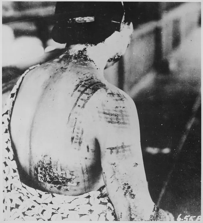 Hombre con tatuajes tradicionales en la espalda en una antigua foto que muestra contexto histórico poco conocido.