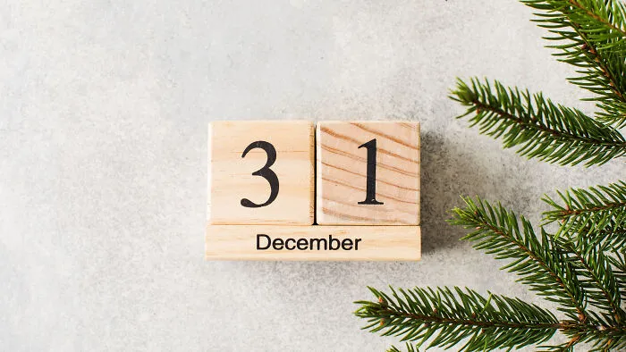 Wooden calendar displaying December 31 with evergreen branches, symbolizing secrets discovered after someone passed.