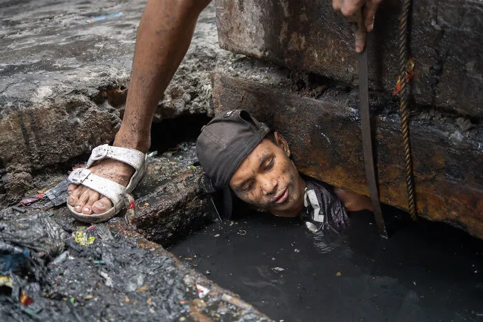 A Worker Unblocking The Sewerage In Manila, Philippines