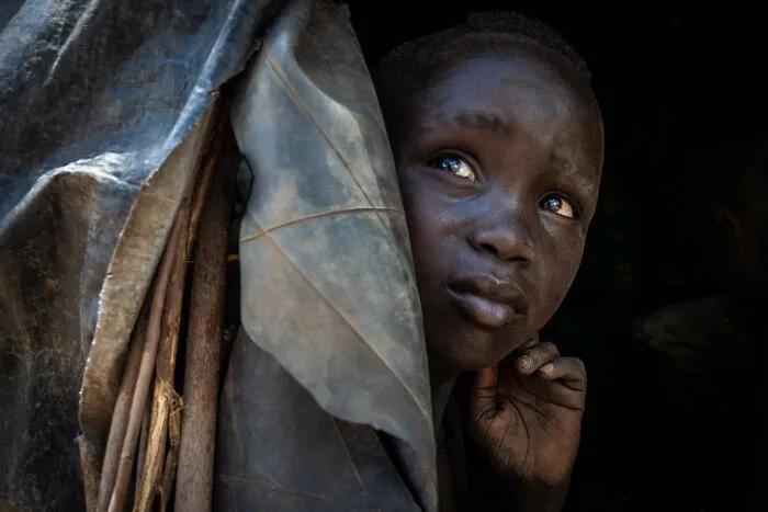A Young Boy Of The Mursi Tribe Photographed At The Entrance To His Very Humble Home, In The Omo Valley, Ethiopia