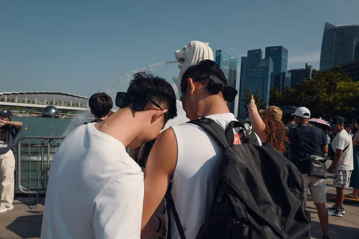 Two men with backpacks near waterfront and cityscape, capturing ordinary moments in poetic, cinematic photography style.