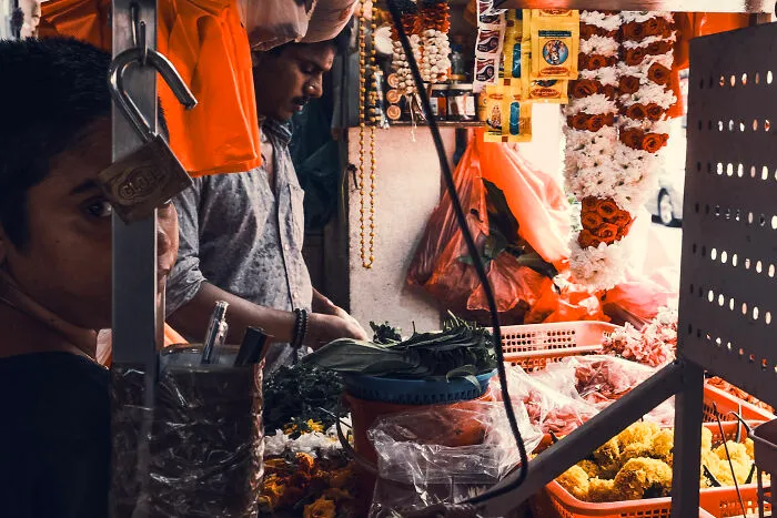 A photographer capturing poetic, cinematic images of a busy flower market with vibrant colors and everyday moments.