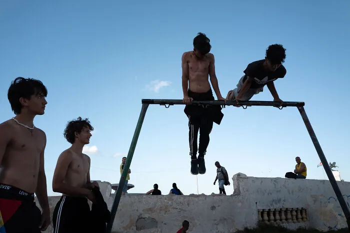 Teen boys enjoying outdoor activity on playground captured by street photographer showcasing beauty of ordinary life.