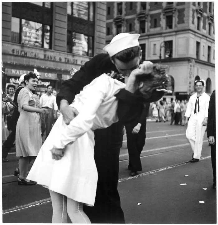 Black and white photo of a sailor kissing a nurse in a street celebration capturing iconic moments in history.
