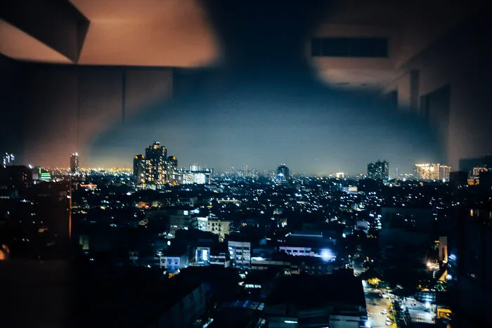 Night cityscape viewed through a window, showcasing a poetic, cinematic image that captures ordinary moments beautifully.