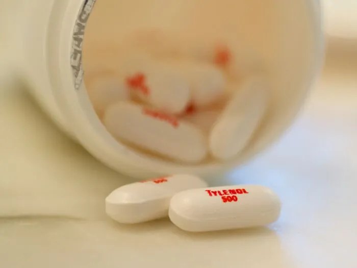 Close-up of Tylenol pills spilled from a bottle, representing health-related unsolved mysteries that still baffle people.