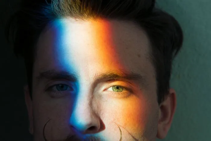Man with colorful light on face, representing hidden families and mob money secrets discovered after someone passed away.