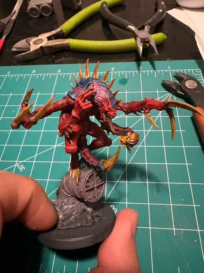 Hand-painted detailed mini creature on a crafting mat with tools, perfect for any man excited to see these pics.