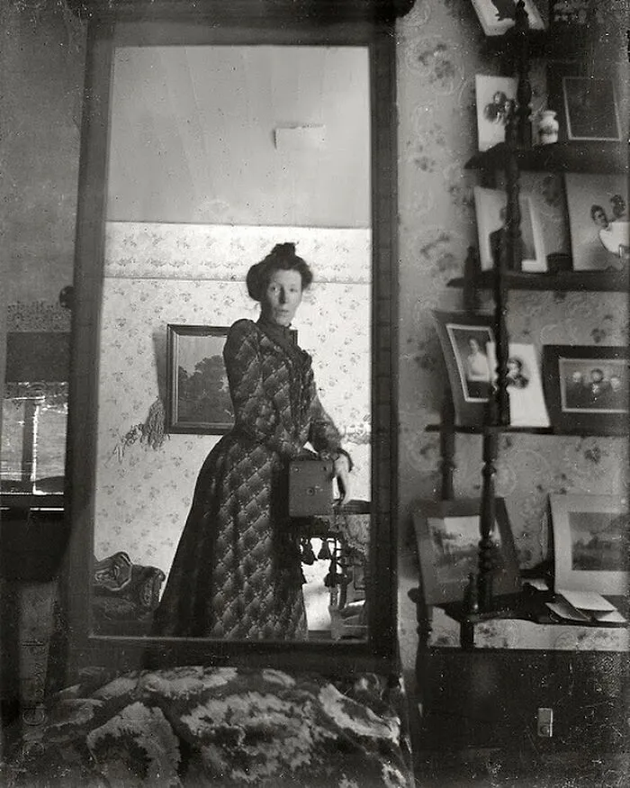 Una mujer de principios de la época eduardiana se toma un selfie en el espejo con una cámara Kodak Brownie en 1900.