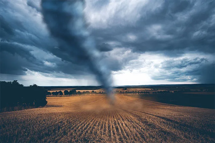 Tornado touching down in an open field under dramatic storm clouds, symbolizing intense moments at the Boston Marathon.