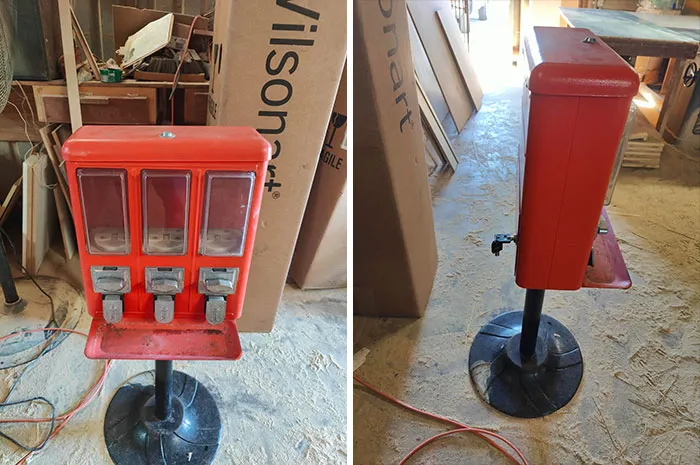 Vintage red candy dispenser on a black pedestal stand, shown from front and side in a rustic thrift store setting.