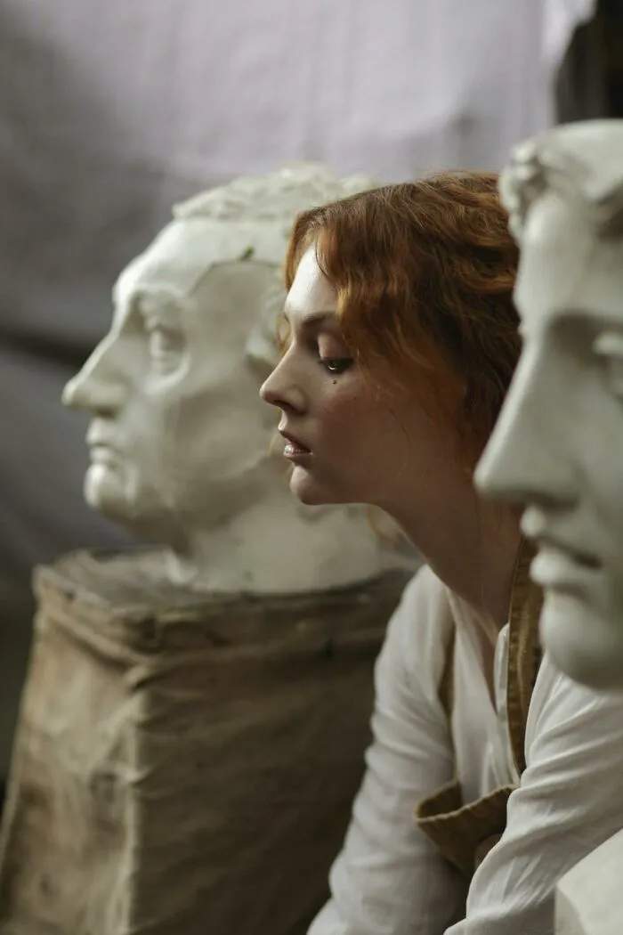 Young woman examining classical sculpture heads, symbolizing reflection on what made them realize they’re talking to a psychopath.