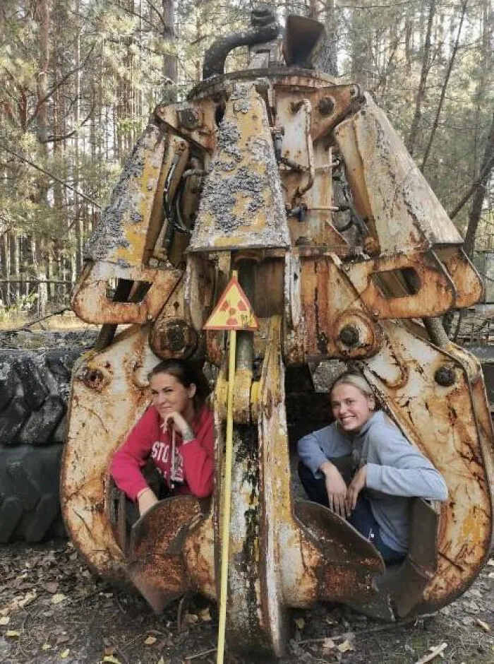Turistas en Chernóbil, sentadas en una garra de excavadora usada tras el desastre. (Contiene niveles letales de radiación).