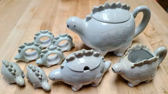 ¡Miren! Mi preciosa tetera de estegosaurio, con recipiente para la crema, azúcarero, salero y pimentero, y, lo más fabuloso e impresionante de todo, ¡servilleteros!