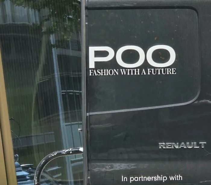 Black van with an advertising placement fail showing the word POO instead of a fashion brand name.