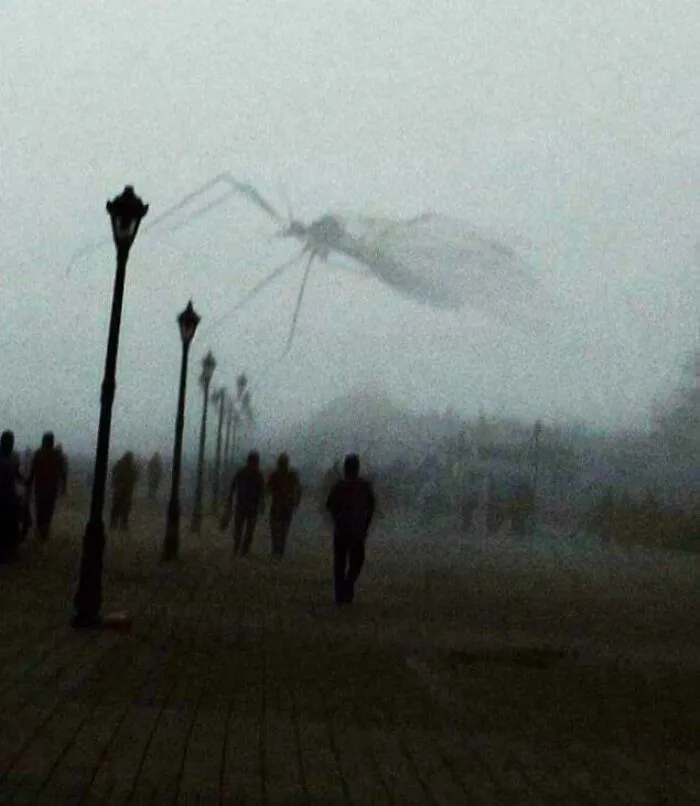 An extremely large, scary, and eerie mosquito-like creature flying over a foggy boardwalk with people.