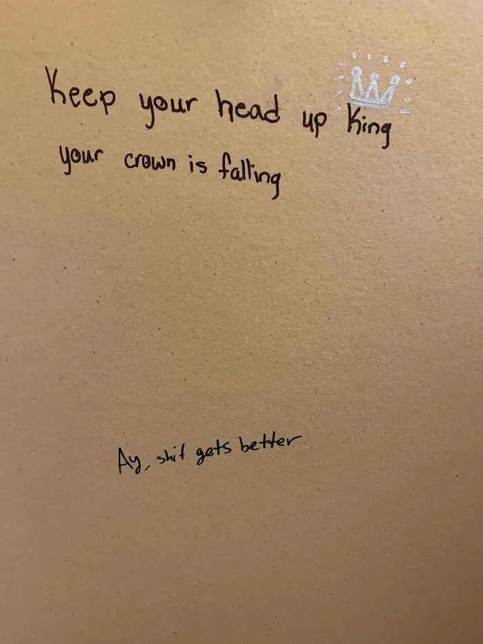 Graffiti vandalized public property with an encouraging message and a small crown drawn on a wall.