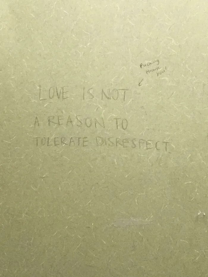 Graffiti on public property reads love is not a reason to tolerate disrespect with a small reply written above.