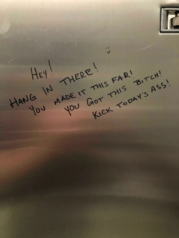 Positive vandalism message written on public property encouraging people to hang in there and kick today's ass.