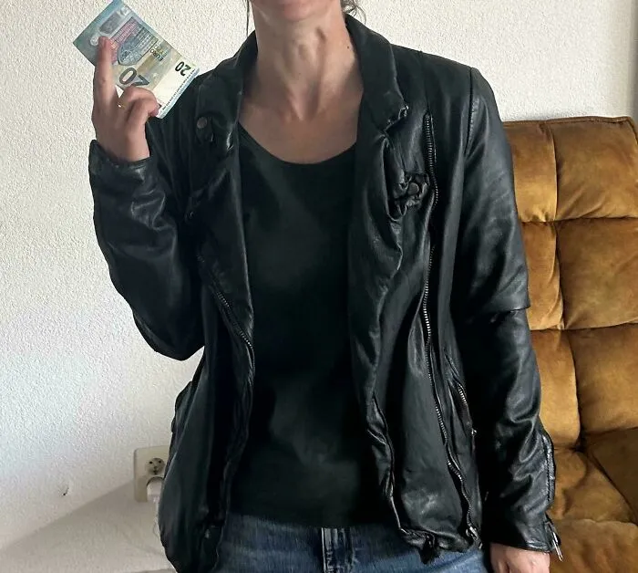 Person wearing a black leather jacket holding cash, illustrating wild Vinted posts and unhinged online selling moments.