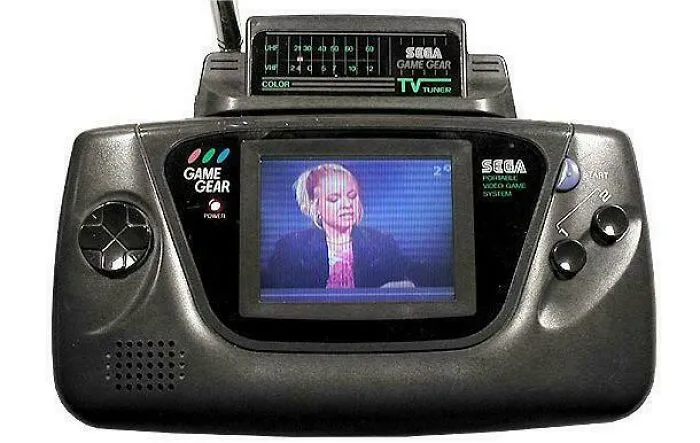 Vintage Sega Game Gear handheld console with TV tuner showing a 90s TV show on screen, evoking nostalgic memories.