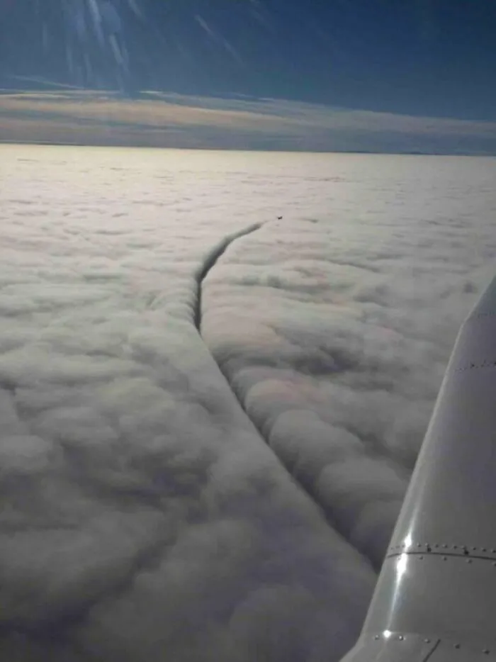 Una nube siendo cortada por un avión