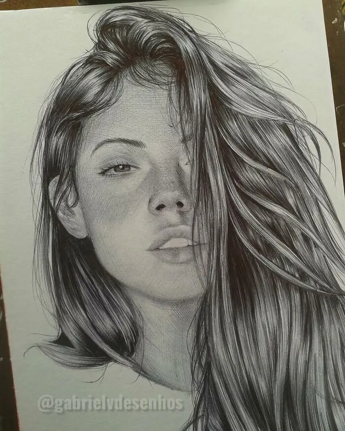 Realistic ballpoint pen portrait drawing of a woman with flowing hair, showcasing detailed shading and lifelike features.