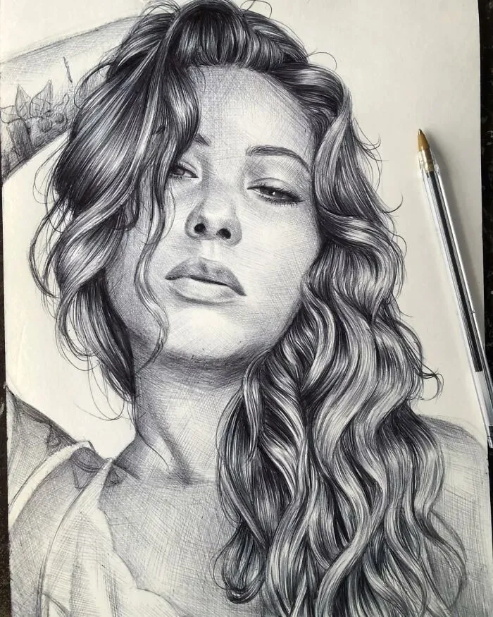 Realistic ballpoint pen portrait of a woman with long wavy hair, showcasing detailed shading and lifelike features.