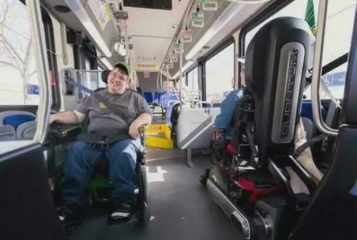 Two men in electric wheelchairs on a city bus, sharing a moment of connection and heartwarming stories.