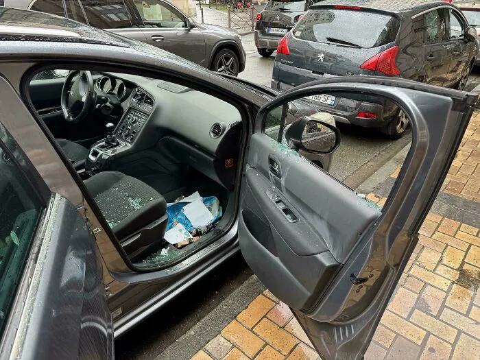 Interior de coche con puerta abierta y vidrio roto, ejemplo de fotos de vacaciones que no salieron como se esperaba.