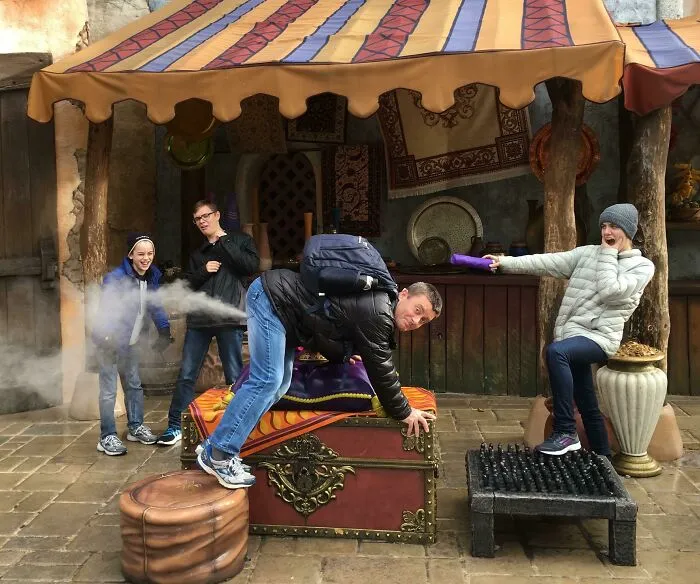 Personas con gran sentido del humor posan en parque de diversiones con bromas y efectos divertidos en sus fotos.