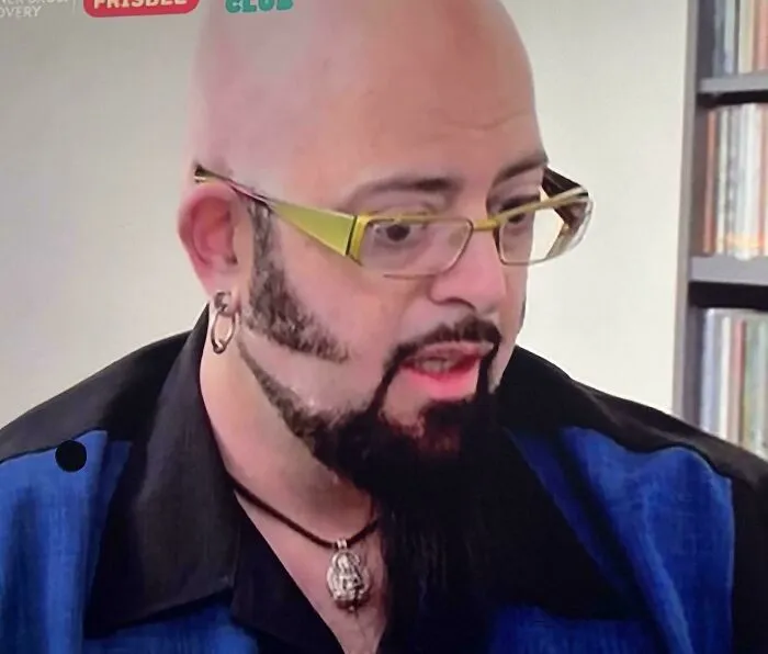A man with a bald head, unique beard, and glasses. This is one of the unfortunate haircuts shared by the community.