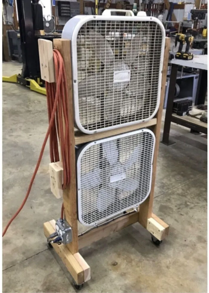 Homemade dual box fan setup on wooden frame with wheels and extension cord, showcasing redneck engineer creativity.