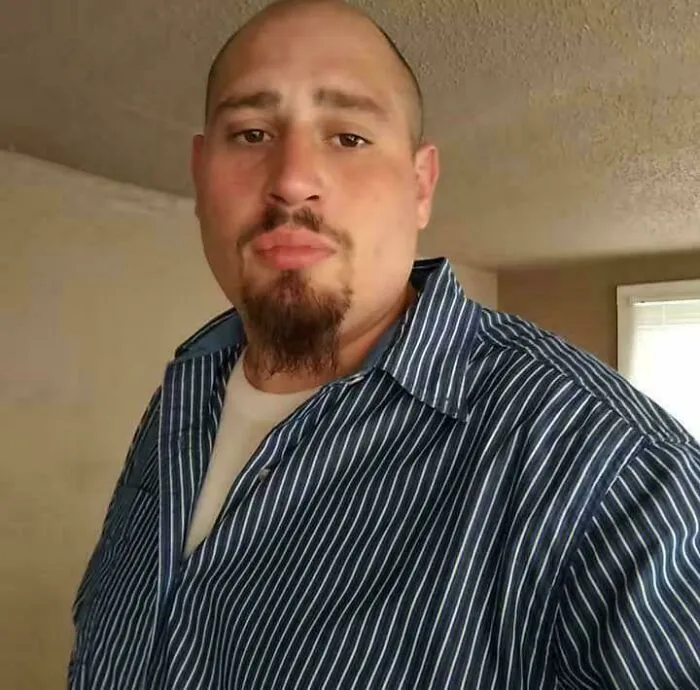Man with goatee wearing a striped shirt indoors, representing still remains undiscovered to this day concept.