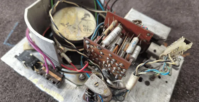 Close-up of old electronic components and wires tangled together, illustrating improper handling in electronics repair.
